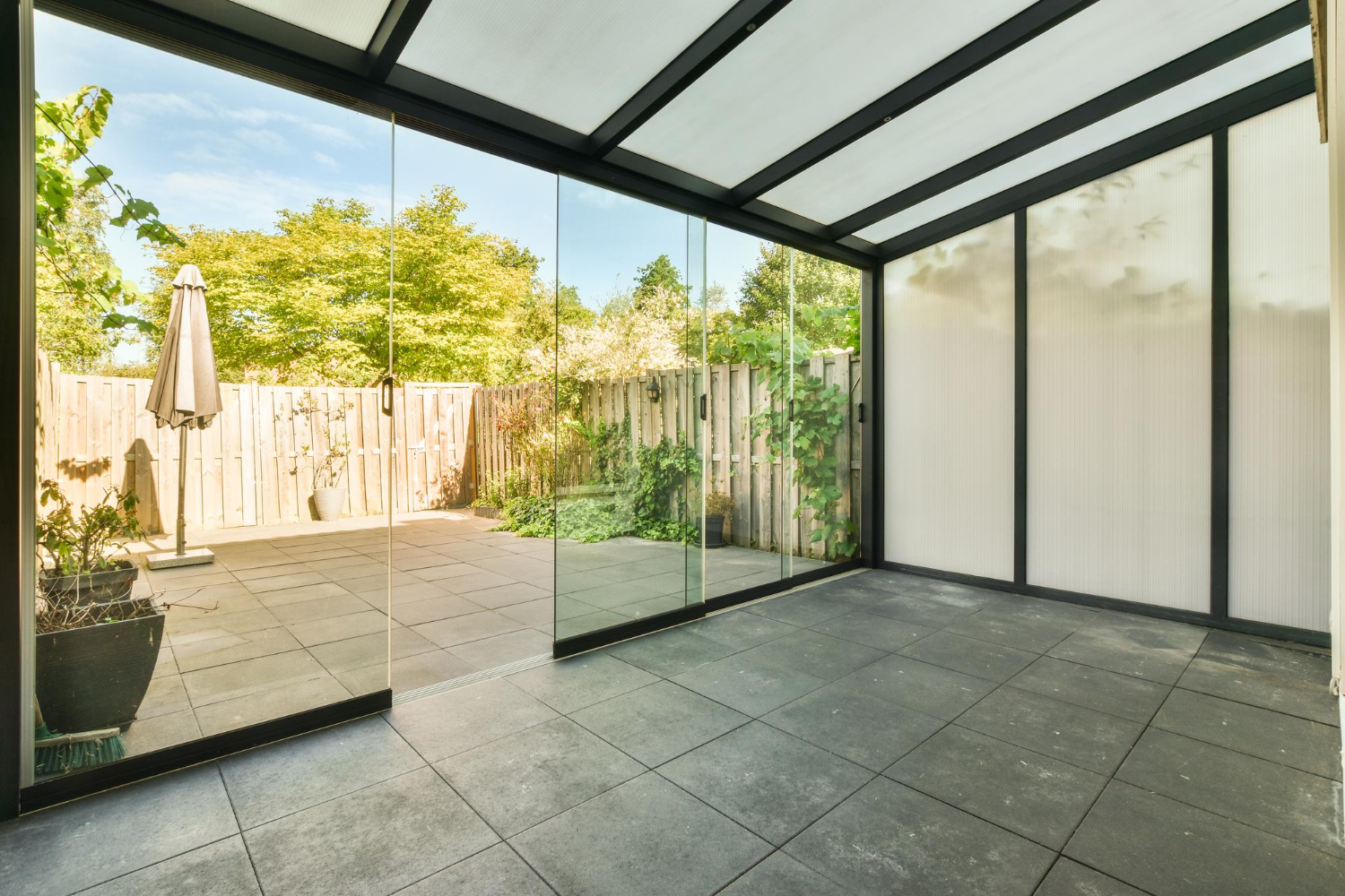 vue sur une veranda vide donnant sur un jardin